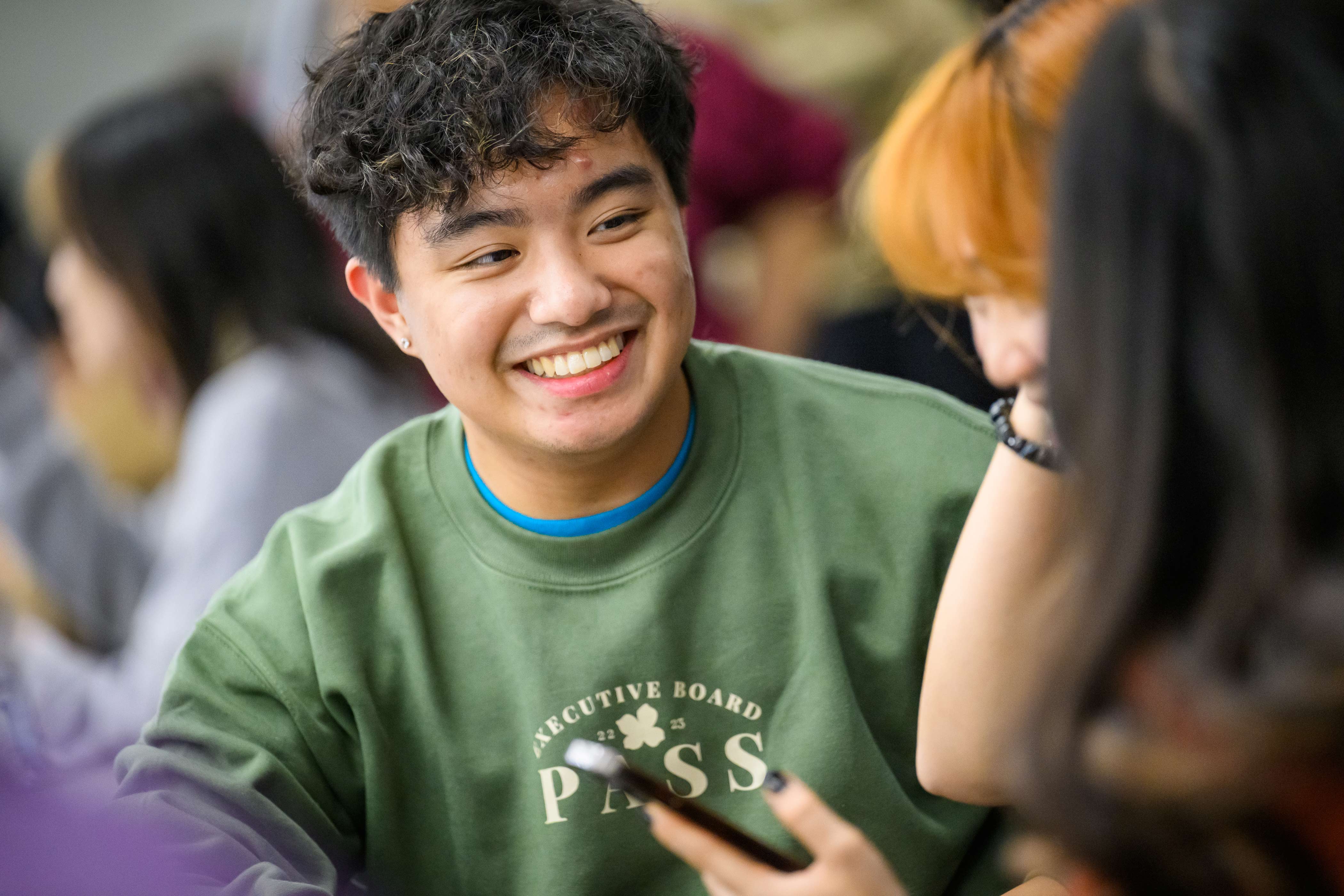 Student smiling in a group conversation
