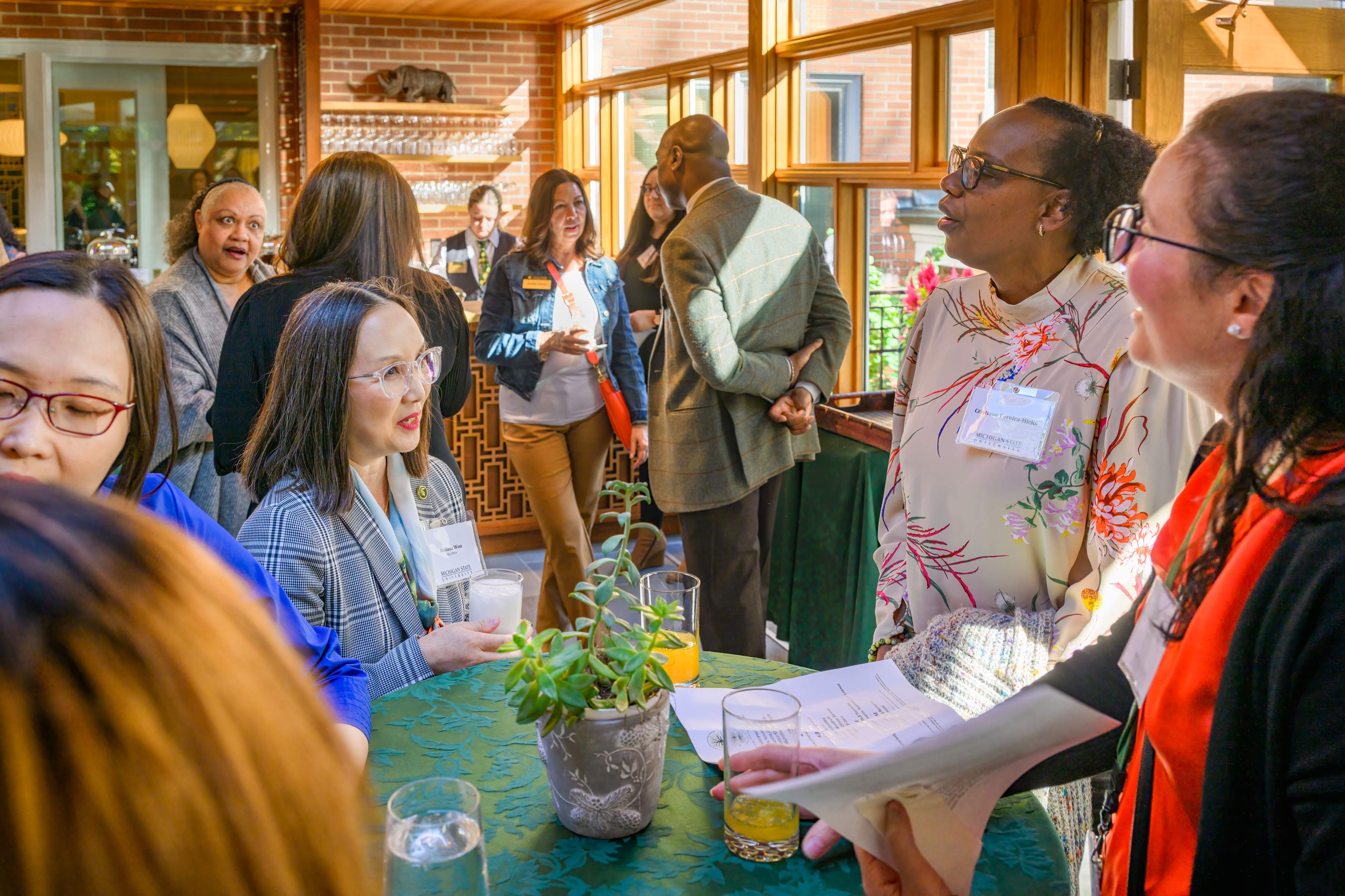 Guests talk amongst each other, including Melissa Woo, Ph.D. (center), executive vice president and chief information officer.