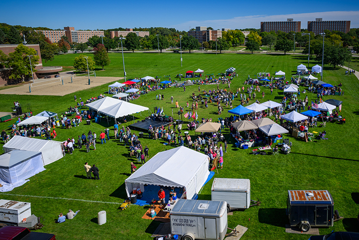 Spread of various tents with people walking around for Powwow.
