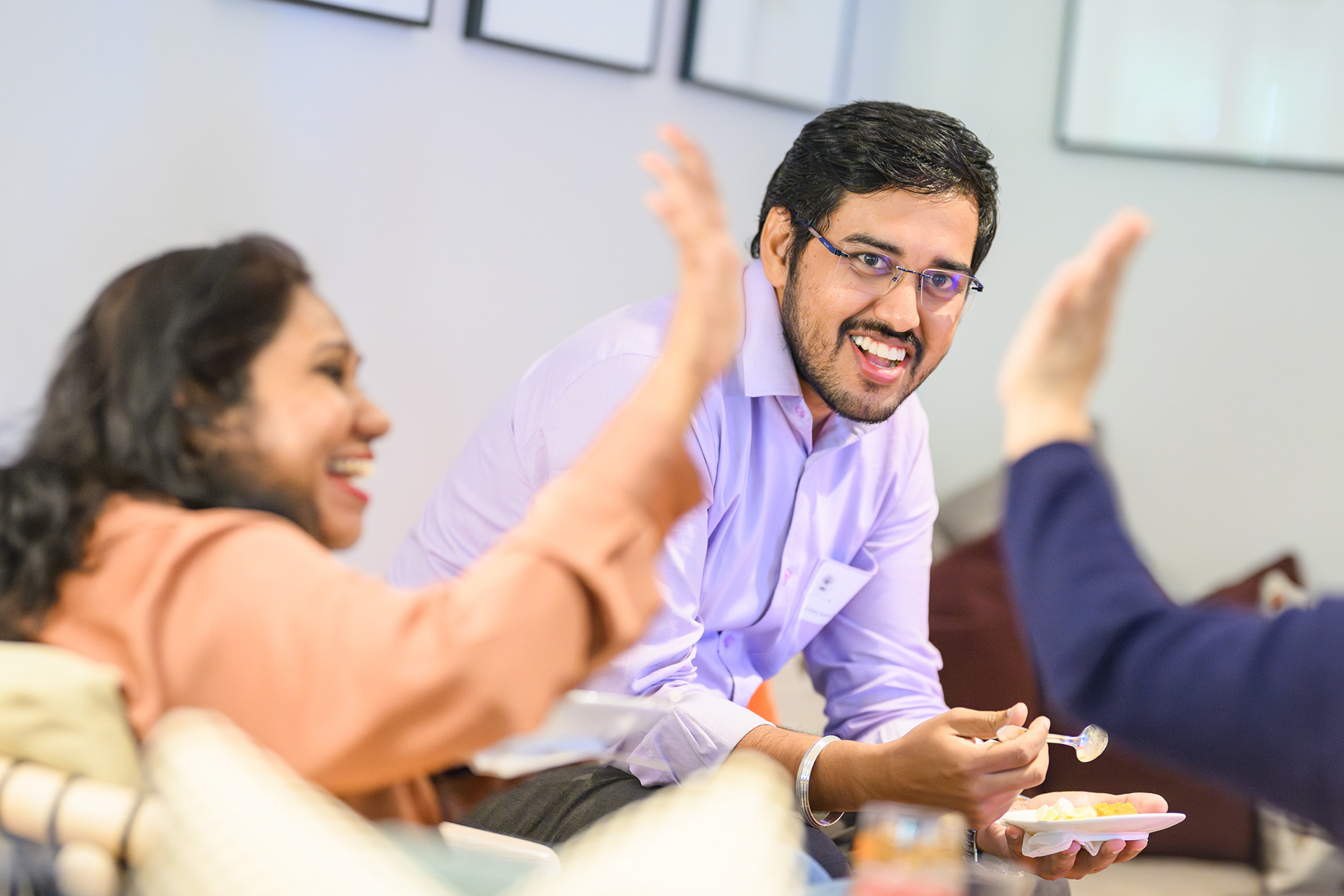 two people high-fiving in foreground with someone smiling in focus in the background