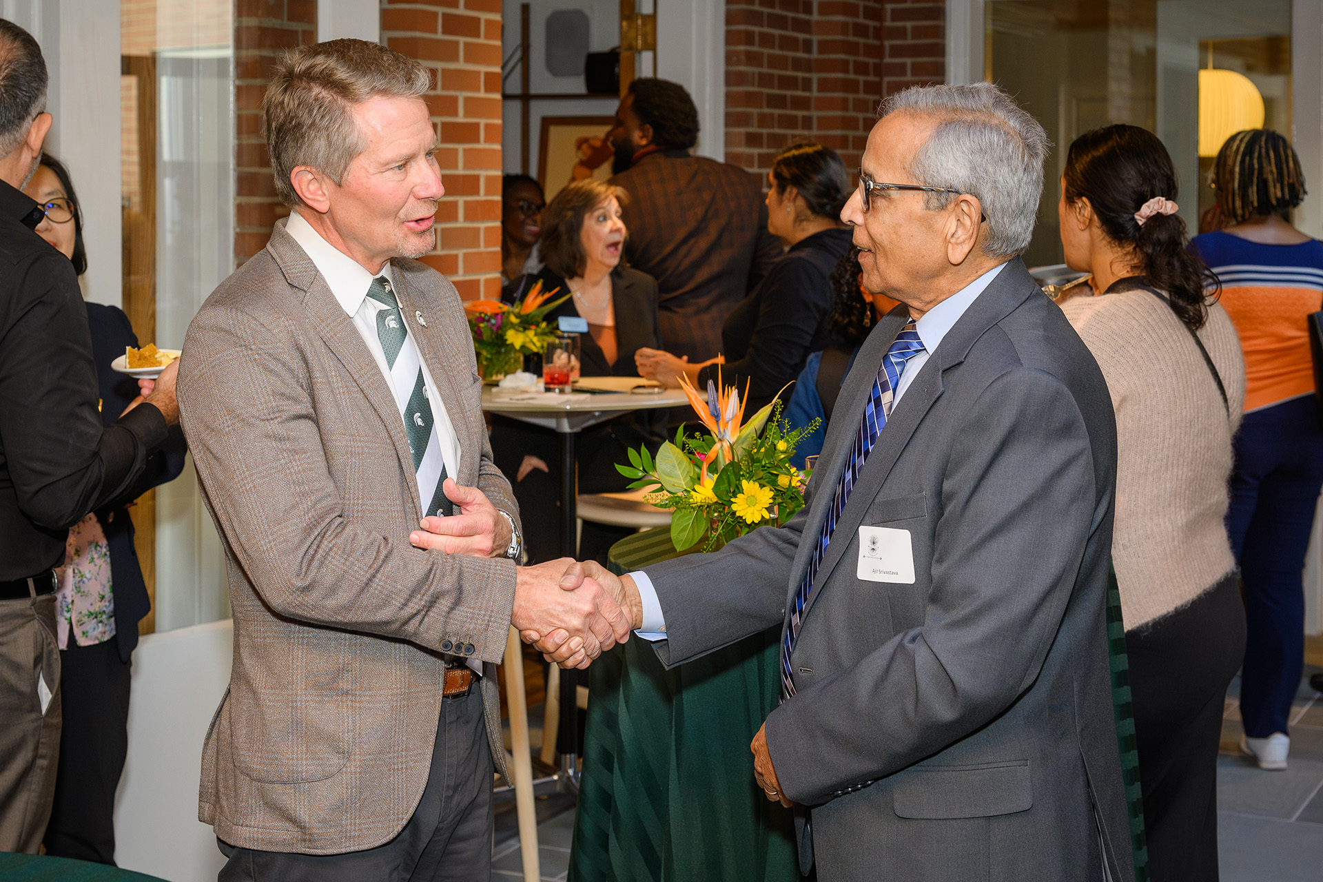 President Guskiewicz shakes hands with a faculty member