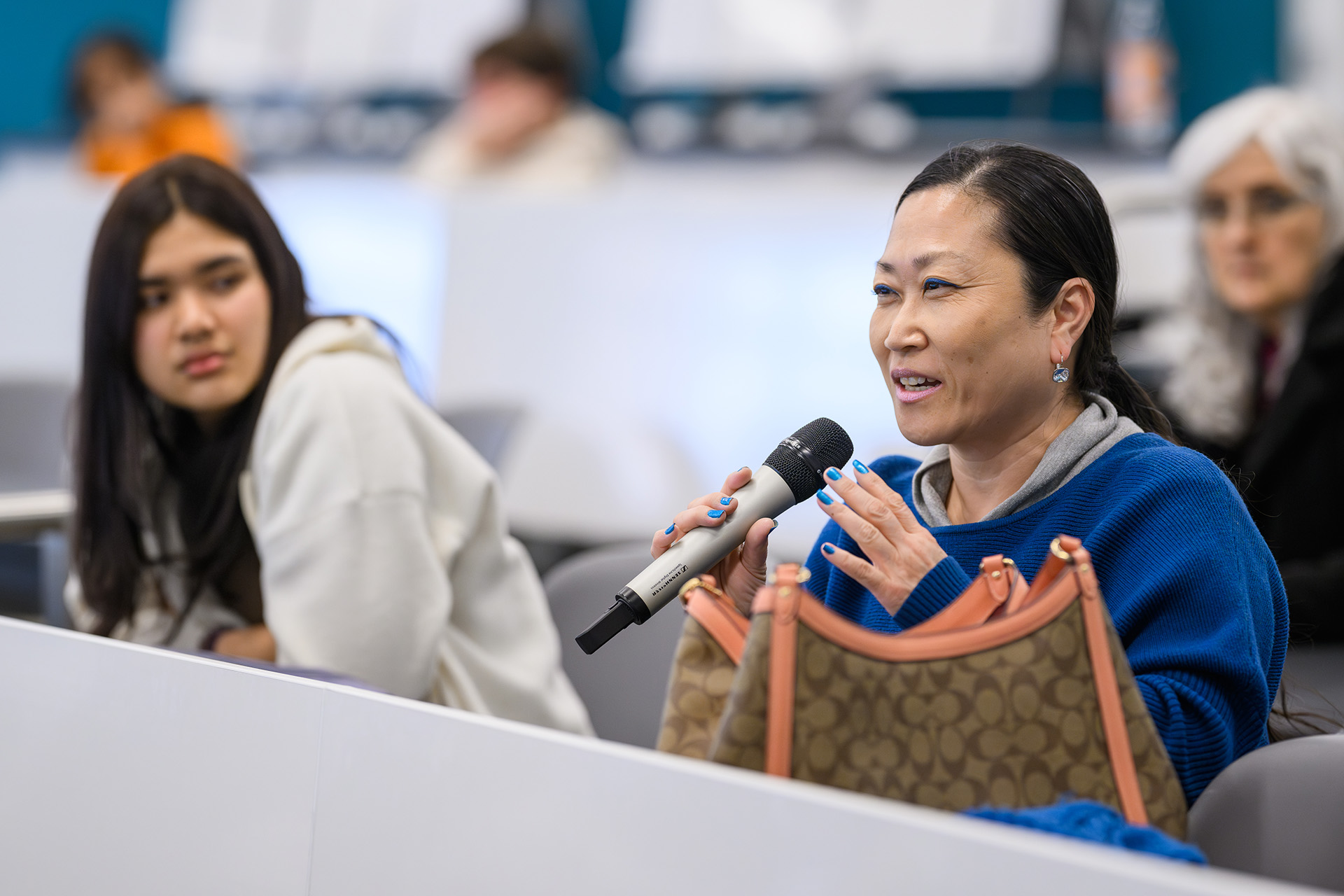 a participant holds a microphone sharing a comment