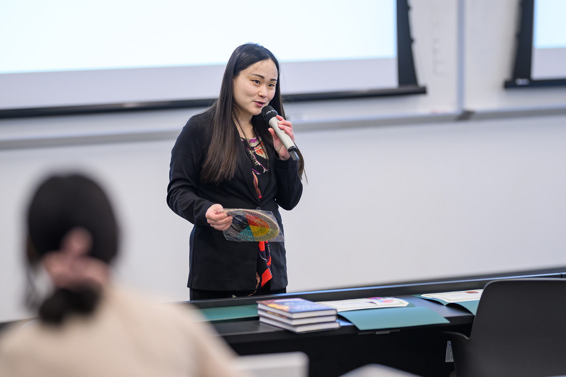 MSU Dialogues coordinator speaks into a microphone at the front of the room