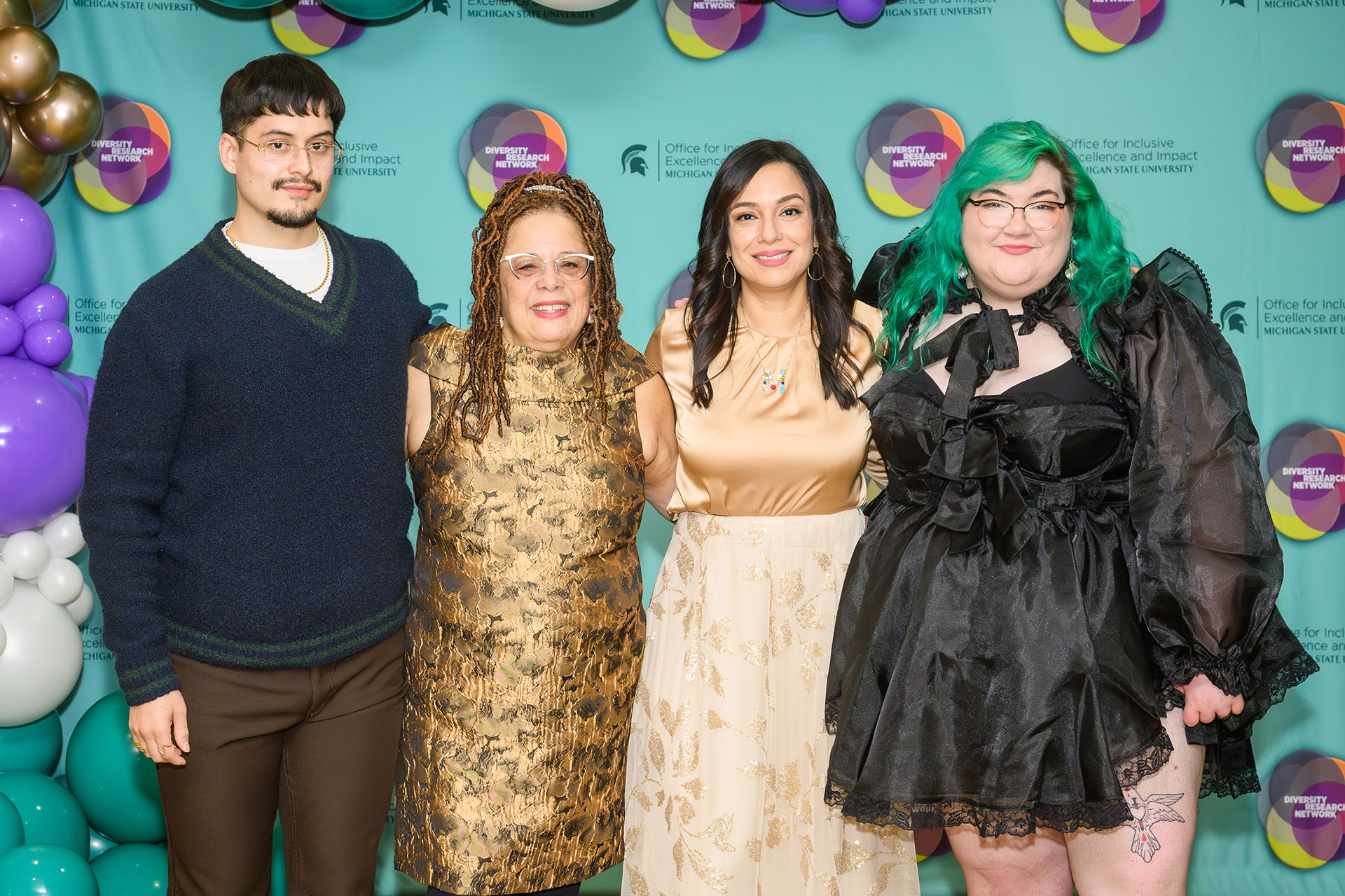 a group of staff take a photo in front of a backdrop