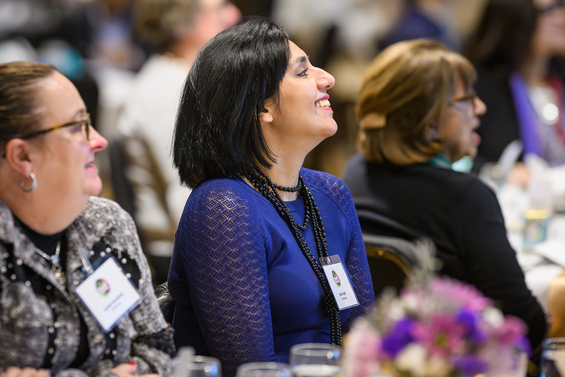 a woman in the audience smiles and looks onward