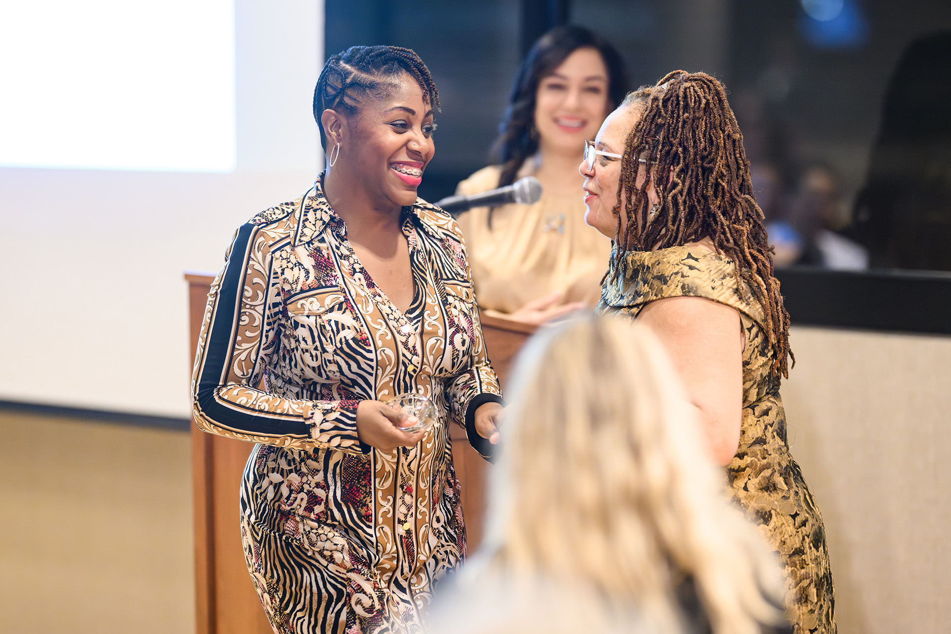 a woman walks up to receive recognition