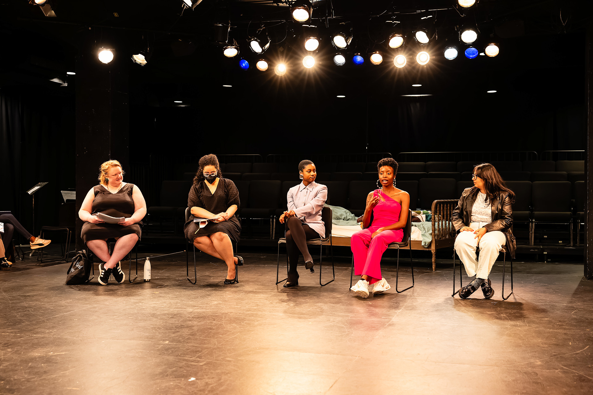 panelists sit on stage taking turns speaking