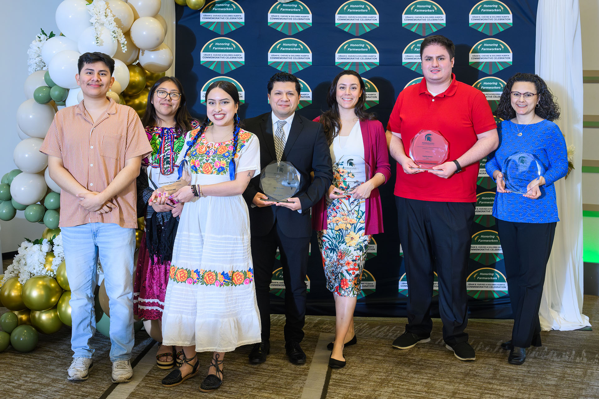 award recipients pose for a photograph in front of a backdrop