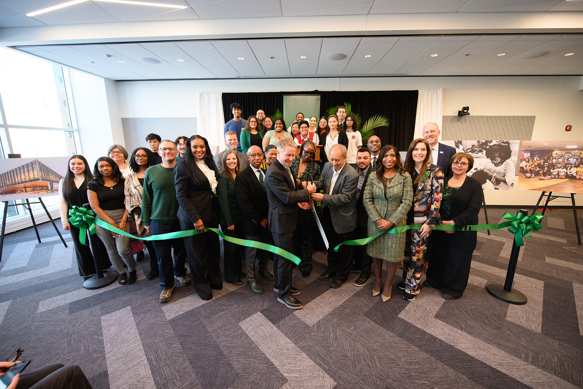 a large group photo with a ceremonial ribbon being cut