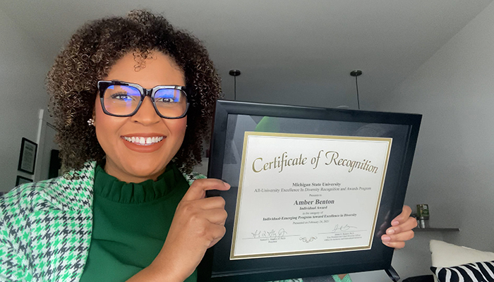 Amber Benton holding up her EIDA award certificate