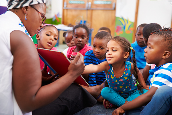 a teacher reading to a group of children