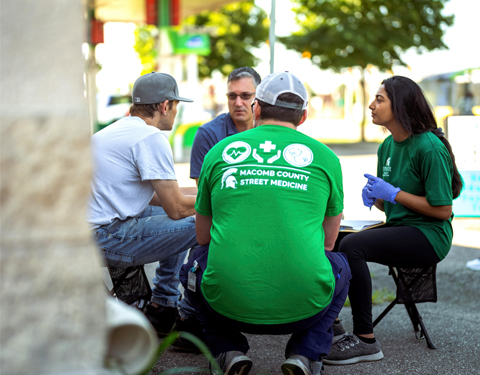 Macomb County Street Medicine team talks with and helps a patient during a recent street run