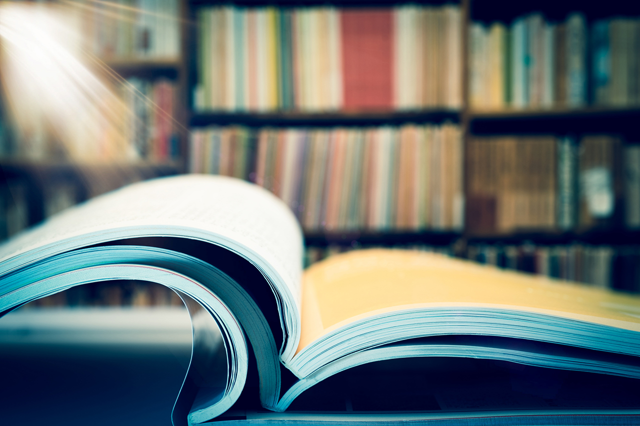 Piles of books and magazines on background of book shelf